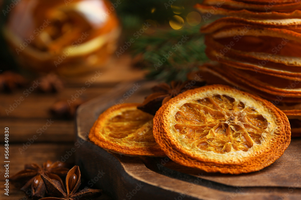 Fototapeta premium Dry orange slices and anise stars on wooden table, closeup. Space for text