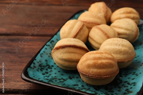 Delicious nut shaped cookies with boiled condensed milk on plate, closeup