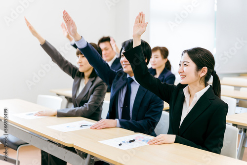 オフィス・会議室で挙手して積極的に質問・意見・発言するビジネスマン・会社員の男女（セミナー） 