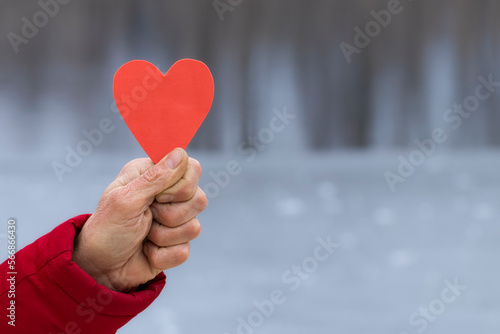 Valentine s Day background with a heart.A man in his hand holds a red paper heart.