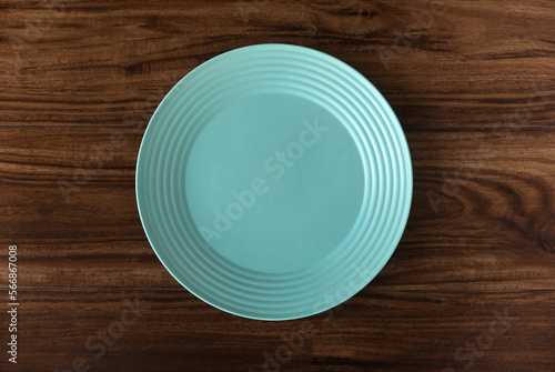 Top view of empty green plate on a wooden background. Flat lay, copy space.