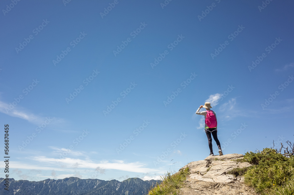 Asian mountain climbing woman pointing at far away