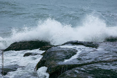 Beautiful Nature scene of sea wave hitting on the black stone shoreline