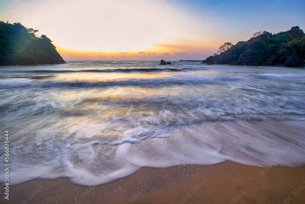 Fototapeta premium The white sea wave that washes ashore on the brown sand beach and the sky in the morning of the day is a tourist attraction of Bang Saphan District. Prachuap Khiri Khan Province.