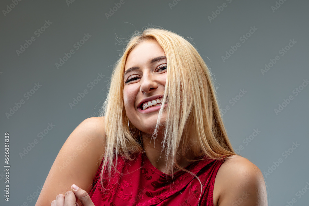 Blond woman smiling, playful, perhaps mischievous or shy Blond woman smiling, playful, perhaps mischievous or shy