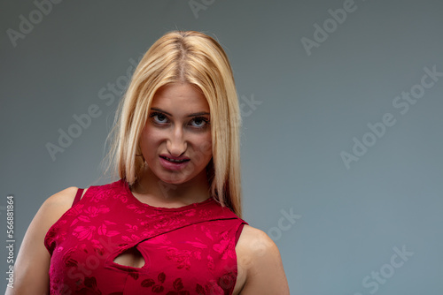 Blond woman giving strong, annoyed gaze in stylish red dress