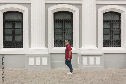 mature man walking in front of colonial classical architecture building