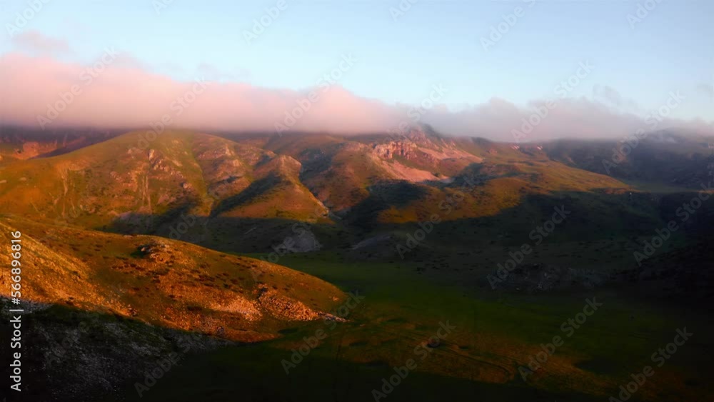 High green mountains of Mavrovo national park illuminated by the setting sun in North Macedonia. backwards drone dolley shot