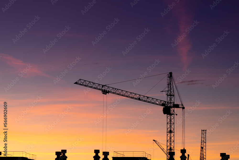 Construction high-rise crane on the background of the sunset sky