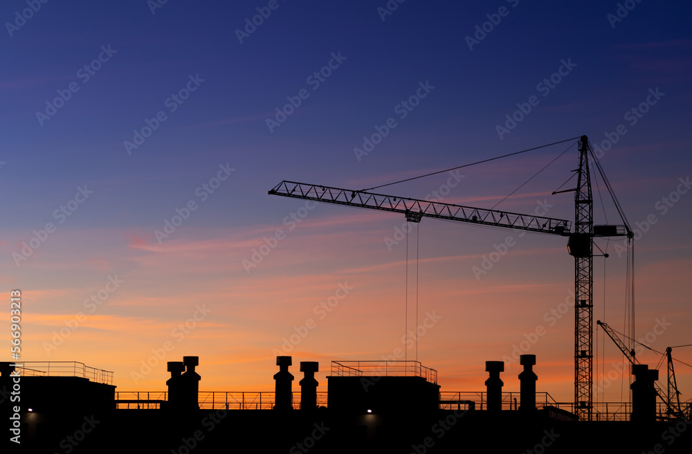 Construction high-rise crane on the background of the sunset sky