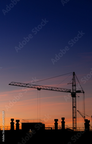 Construction high-rise crane on the background of the sunset sky