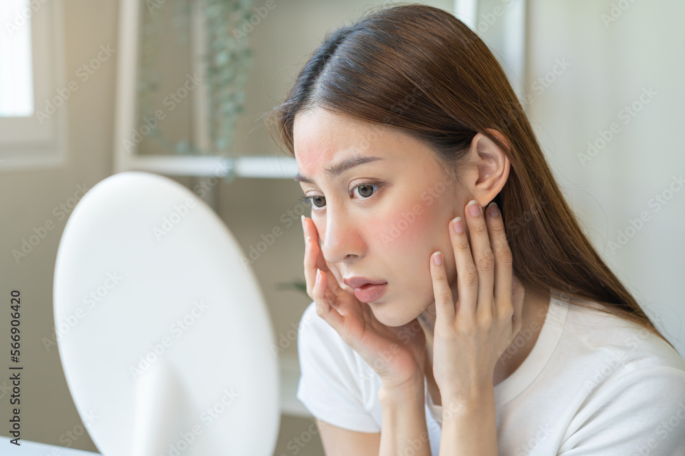 Dermatology, scratch asian young woman looking at mirror, expression worry and itch, itchy allergy or allergic sensitive reaction, red spot or rash on her face. Beauty care from skin problem treatment Dermatology, scratch asian young woman looking at mirror, expression worry and itch, itchy allergy or allergic sensitive reaction, red spot or rash on her face. Beauty care from skin problem treatment