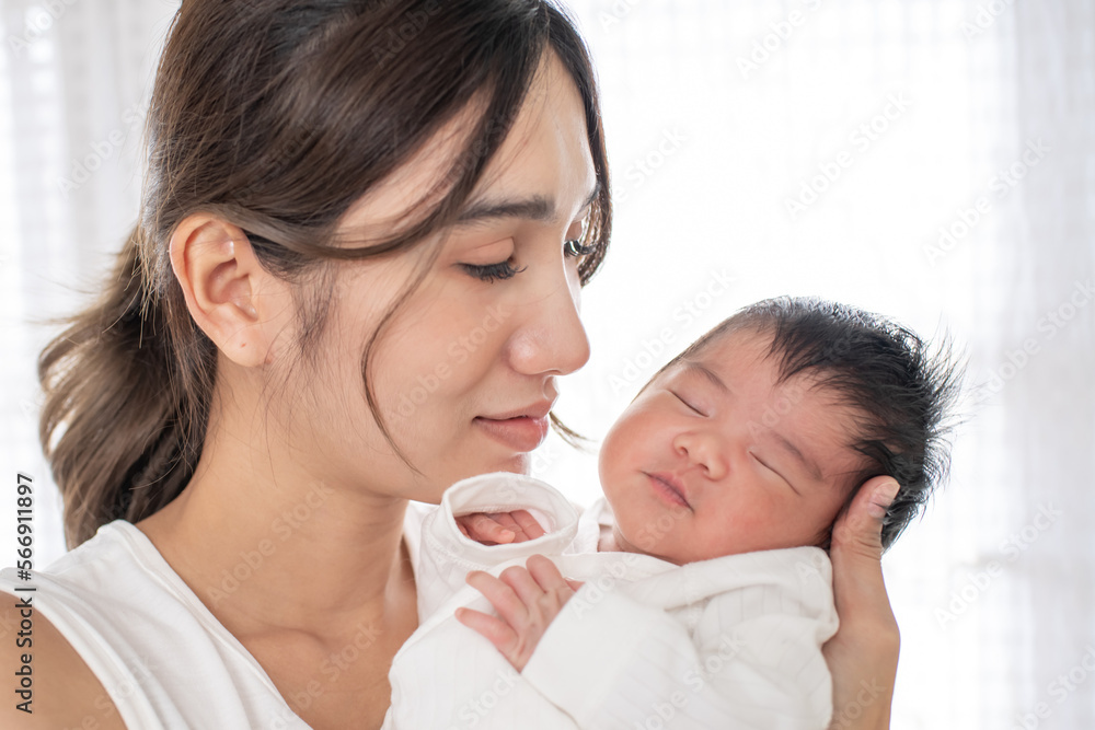 happy loving family. mother playing with her baby hugging in the bedroom , portrait of asian mother playing with newborn baby, health care family love together. asian girl lifestyle.. happy loving family. mother playing with her baby hugging in the bedroom , portrait of asian mother playing with newborn baby, health care family love together. asian girl lifestyle..