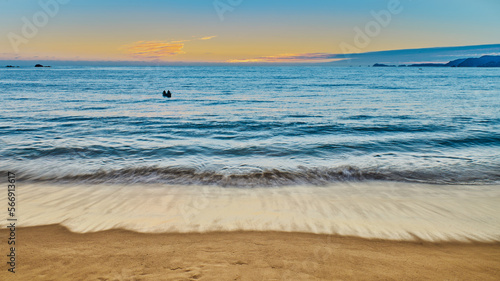 sunset on the beach with sunset and a person in a canoe