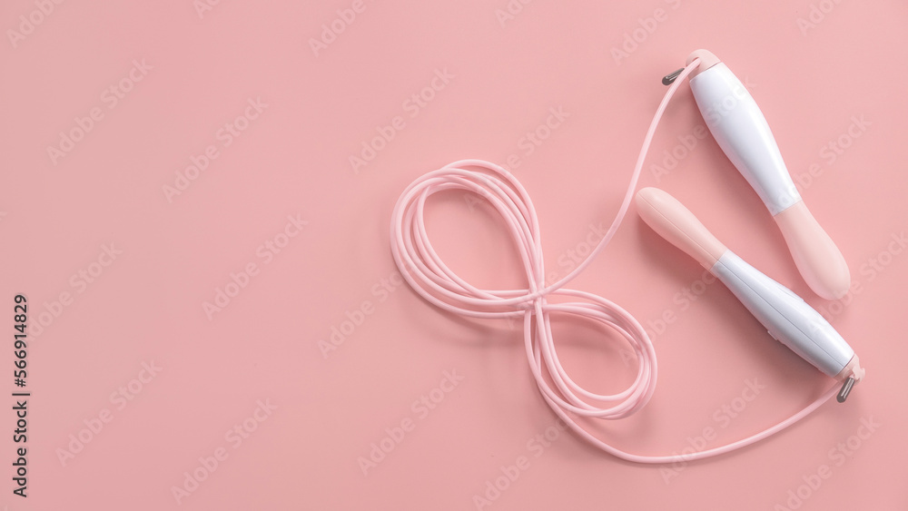 Fitness and healthy sport concept. Pink jumping rope on a pastel pink background. Top view, flat lay, copy space