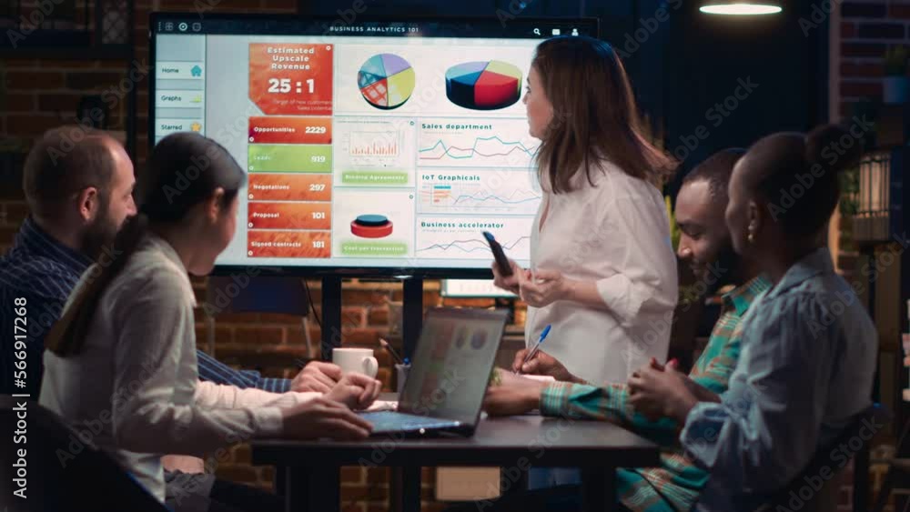 Company employee explaining analytics research results in business meeting, showing statistics data on digital board. Marketing revenue report presentation, colleagues team planning sales strategy Company employee explaining analytics research results in business meeting, showing statistics data on digital board. Marketing revenue report presentation, colleagues team planning sales strategy