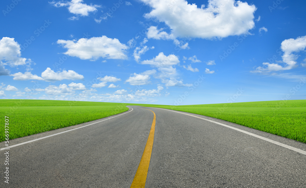 Tarmac road in slope grass field with blue sky background. Tarmac road in slope grass field with blue sky background.