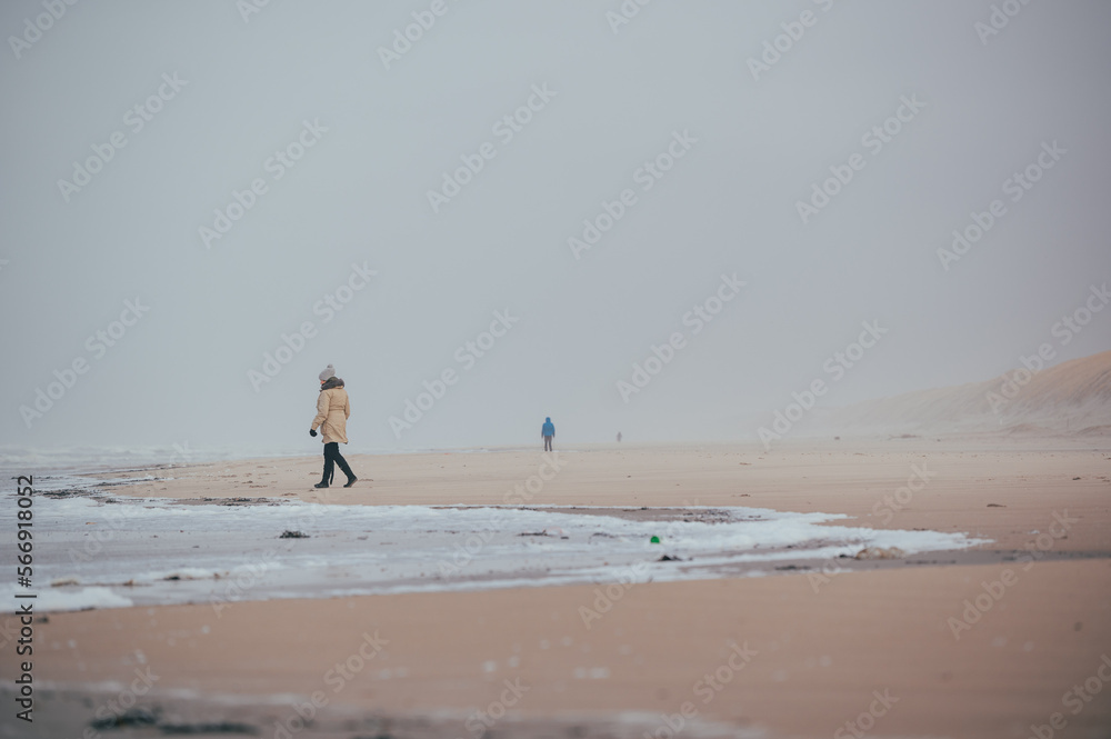 eine einzige kleine Menschengruppe am stürmischen weitläufigen Strand in Dänemark