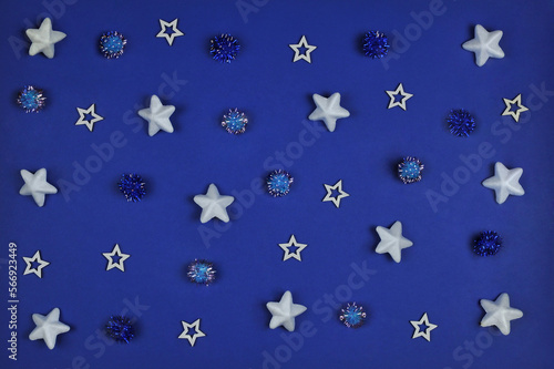 White stars and blue and dark blue decorative glitter balls on dark blue background .Top view  flat lay.