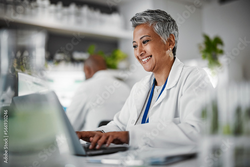 Scientist, senior woman and lab with laptop, research and plants with analytics, pharmaceutical study and focus. Elderly science expert, computer and typing for data analysis for goal in laboratory