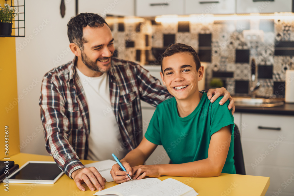 Father is helping his son with learning. They are doing homework together. Father is helping his son with learning. They are doing homework together.