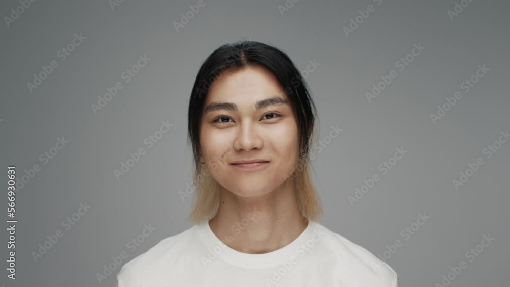 Portrait of Young Korean Man Looking at Camera in Color Studio Shot. Adult Japanese Boy Isolated Alone on Grey Background Closeup. Asian Person Opening Beautiful Eyes and Smiling Friendly and Happy Portrait of Young Korean Man Looking at Camera in Color Studio Shot. Adult Japanese Boy Isolated Alone on Grey Background Closeup. Asian Person Opening Beautiful Eyes and Smiling Friendly and Happy