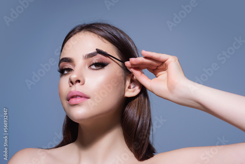 Eyebrow shaping  woman combs eyebrows with a brus. Eyebrow line. Makeup and cosmetology concept. Female model with long eyelashes and thick eyebrows. Perfect shaped brow.