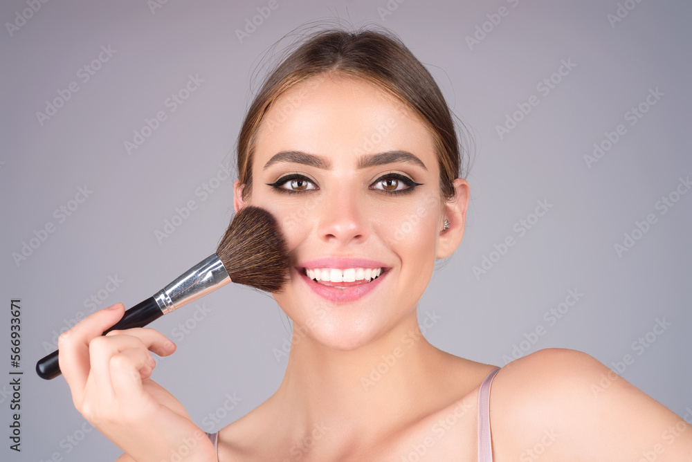 Beautiful woman applying make-up powder on the cheek. Cosmetic powder brush. Perfect skin and natural makeup. Beautiful woman applying make-up powder on the cheek. Cosmetic powder brush. Perfect skin and natural makeup.