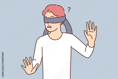 Frightened teen boy blindfolded trying to grope road of action in blind
