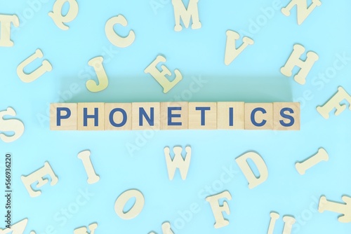 Study phonetics in linguistics concept. Wooden blocks word typography flat lay in blue background. photo