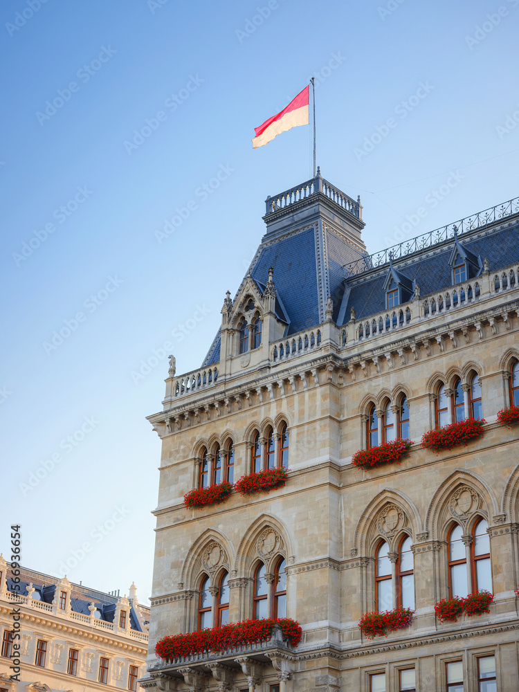 Scenic view of Viena capital, impressive gothic architecture of City hall or Rathaus . Travel and landmarks of Austria, details and flowers and flag of Vienna on buildings
