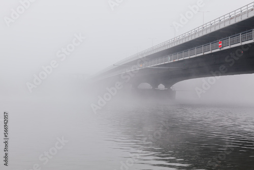Fog over the bridge and river . Misty morning at riverside