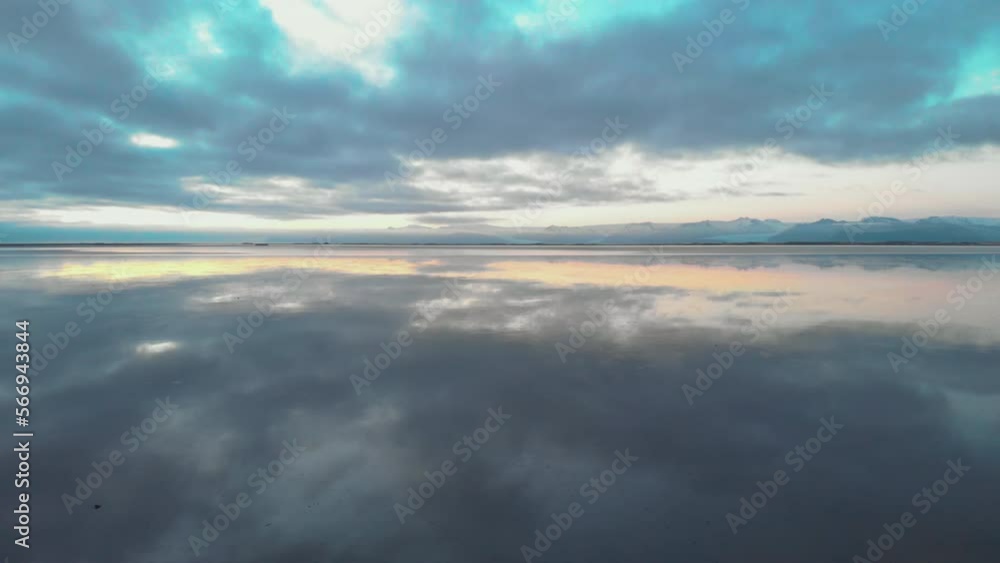 Surreal mirror reflection sunrise cloudscape in calm Icelandic ocean water Surreal mirror reflection sunrise cloudscape in calm Icelandic ocean water