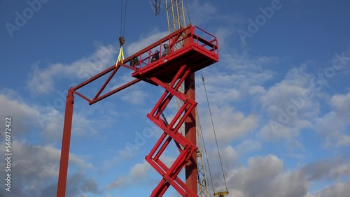 Workers are lifting on the Aerial Work Platform (Scissor lift) to secure the beam frame