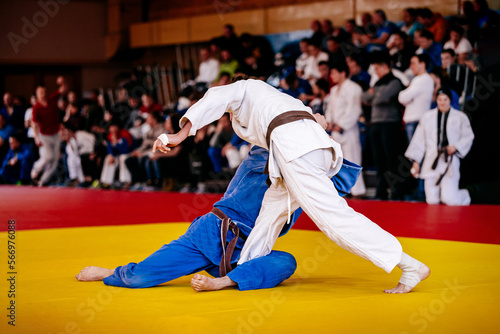 athletes judoists wrestling on tatami in judo competition