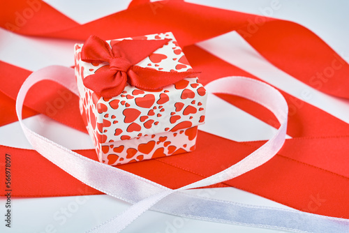 Background image of red and white ribbons and a small gift box with a rat bow.