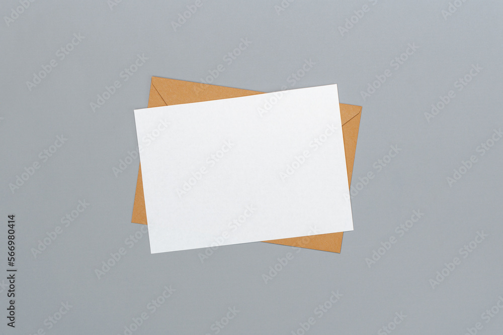 Above view studio shot of an envelope made of craft paper and blank white postcard isolated on grey background Above view studio shot of an envelope made of craft paper and blank white postcard isolated on grey background