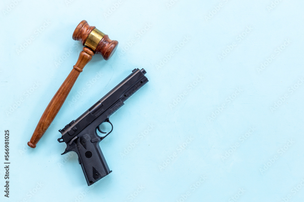 Hand gun weapon and judges gavel - gun law. Illegal use of weapons concept Hand gun weapon and judges gavel - gun law. Illegal use of weapons concept