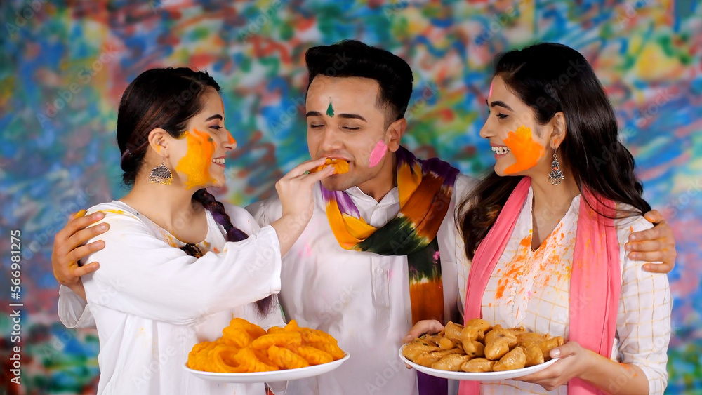 Group of young people greeting each other on Holi festival - Holi celebration . Pretty woman feeding an Indian sweet Imarti to an attractive guy on the Hindu festival of Holi - festive spirit swee... Group of young people greeting each other on Holi festival - Holi celebration . Pretty woman feeding an Indian sweet Imarti to an attractive guy on the Hindu festival of Holi - festive spirit swee...