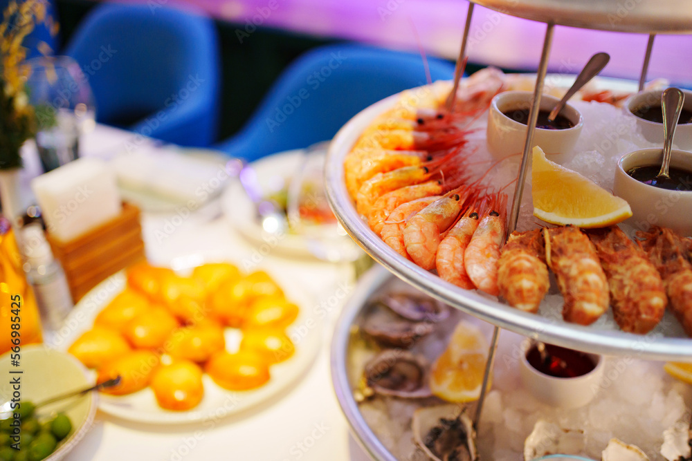 shrimp and shells with oysters on a platter with ice, lemons and sauce. shrimp and shells with oysters on a platter with ice, lemons and sauce.