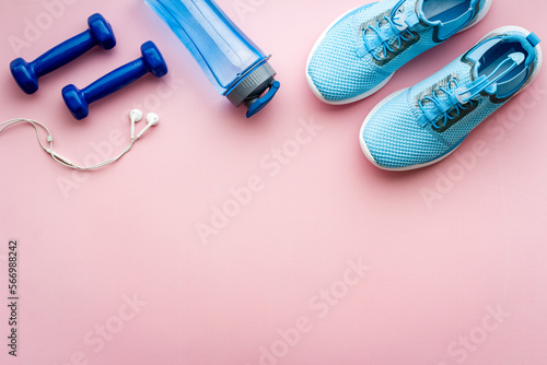 Sport background with sneakers and dumbbells, top view
