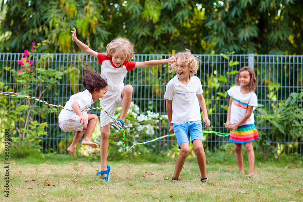 Fototapeta premium Happy kids play outdoor. Children skipping rope.