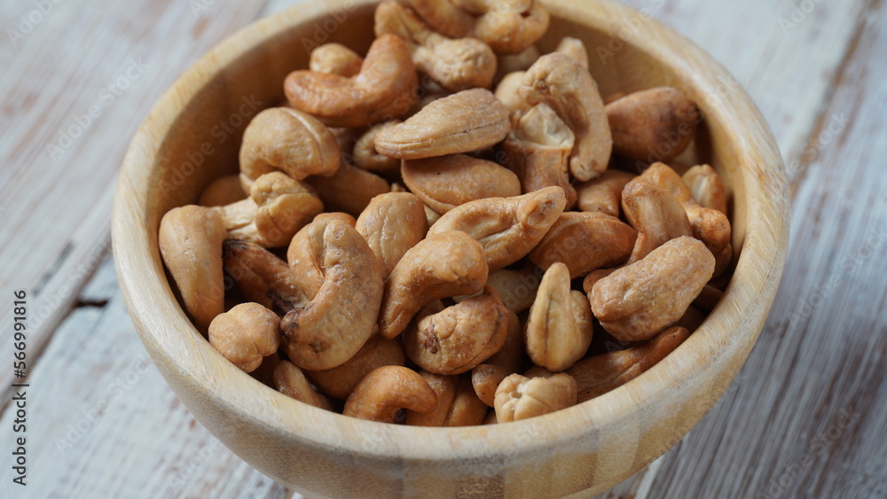 Wooden bowl with mix nuts: Walnut, pistachios, almonds, hazelnuts and cashews on a table Wooden bowl with mix nuts: Walnut, pistachios, almonds, hazelnuts and cashews on a table