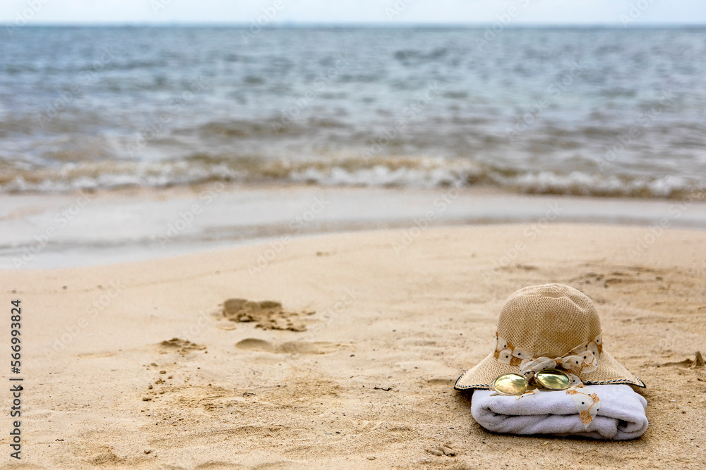 Beach cap with a towel and sunglasses on a white sandy Caribbean beach under the radiant and warm rays of the sun, ideal place for tourists to enjoy summer vacations. Beach cap with a towel and sunglasses on a white sandy Caribbean beach under the radiant and warm rays of the sun, ideal place for tourists to enjoy summer vacations.