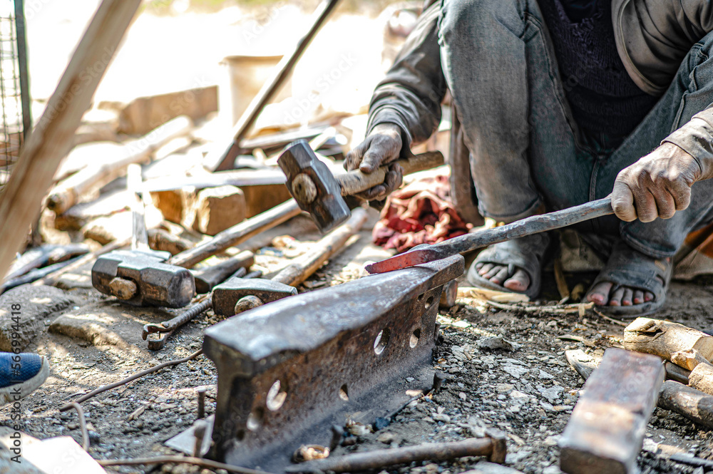 A blacksmith is forging iron rods into tools. Equipment at a roadside blacksmith shop in India A blacksmith is forging iron rods into tools. Equipment at a roadside blacksmith shop in India