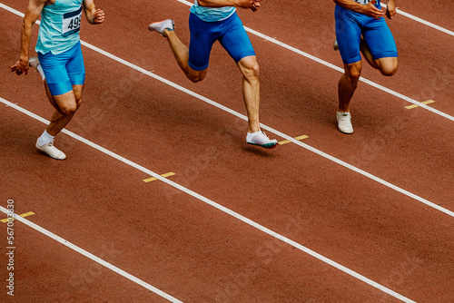 group male runners run on track stadium in track and field competition