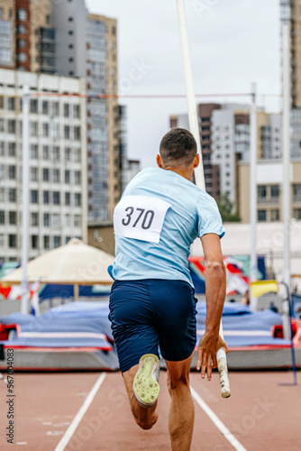 run-up male athlete pole vault at athletics competition photo