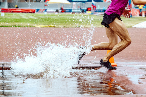 Obraz na plátně steeplechase race legs male runner splashing water