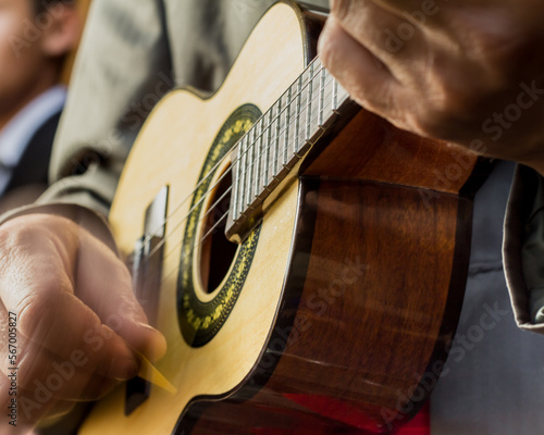 Hands of an white man playing an small samba guitar called cavaquinho or cavaco photo