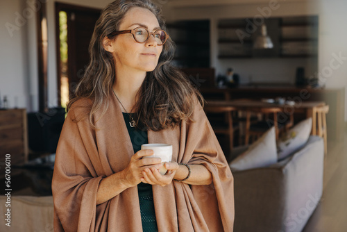 Thoughtful senior woman holding a tea cup at home